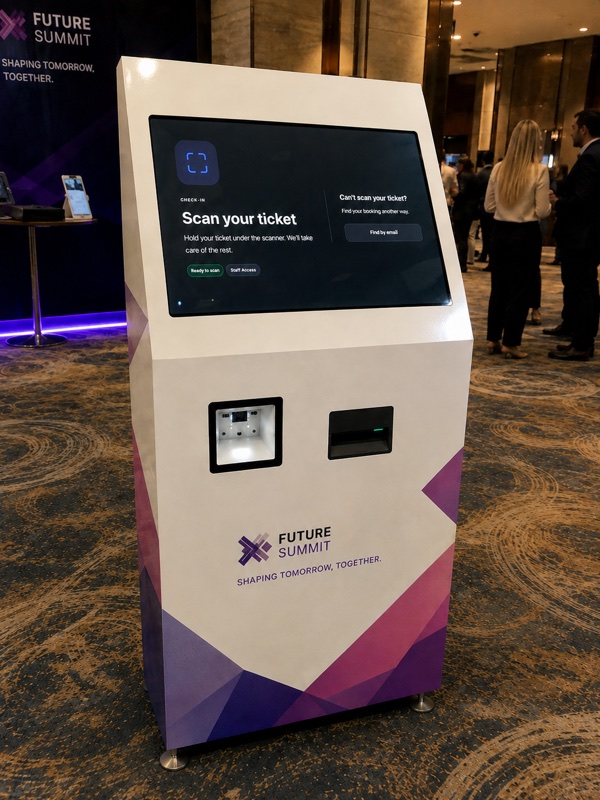 Real event registration area at Future Summit with the self-service kiosk and venue team in view